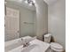 Well-lit half bathroom featuring a large mirror, white sink, and toilet at 12060 Carriage Park Ln, Duluth, GA 30097