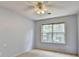 A cozy bedroom with a ceiling fan and a large window offering natural light at 12060 Carriage Park Ln, Duluth, GA 30097