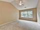 A spacious bedroom with plush carpet, ceiling fan, and large window creating a relaxing ambiance at 12060 Carriage Park Ln, Duluth, GA 30097