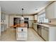 Eat-in kitchen offers white cabinets, stainless appliances, and a center island with wood countertop at 12060 Carriage Park Ln, Duluth, GA 30097