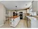 Bright kitchen features white cabinets, stainless appliances, and a center island with wood countertop at 12060 Carriage Park Ln, Duluth, GA 30097
