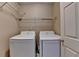 Cozy laundry room equipped with a side-by-side washer and dryer, and wire shelving at 12060 Carriage Park Ln, Duluth, GA 30097