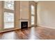 Bright living room boasts a fireplace with tall windows, and hardwood floors for a grand yet inviting atmosphere at 12060 Carriage Park Ln, Duluth, GA 30097