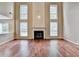 Bright living room boasts a fireplace with tall windows, and hardwood floors for a grand yet inviting atmosphere at 12060 Carriage Park Ln, Duluth, GA 30097