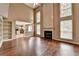 Bright living room boasts a fireplace with tall windows, and hardwood floors for a grand yet inviting atmosphere at 12060 Carriage Park Ln, Duluth, GA 30097