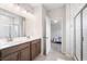 Bathroom view featuring a double vanity, tile shower with glass door, and doorway to bedroom at 218 Ellis Ln, Woodstock, GA 30189