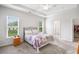 Bright bedroom featuring large windows, a tray ceiling with ceiling fan, and neutral gray carpet at 218 Ellis Ln, Woodstock, GA 30189
