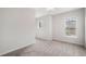 Empty bedroom featuring neutral walls, gray carpet, and a large window overlooking the neighborhood at 218 Ellis Ln, Woodstock, GA 30189