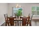 Dining room with a wood table, chairs, chandelier, and view of trees through a sliding glass door at 218 Ellis Ln, Woodstock, GA 30189