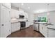 Well-lit kitchen featuring stainless steel appliances, white cabinets, and dark hardwood flooring at 218 Ellis Ln, Woodstock, GA 30189