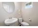 Neat powder room featuring a pedestal sink, toilet, and small window for natural light at 218 Ellis Ln, Woodstock, GA 30189