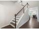 Elegant staircase with dark wood treads and white risers, leading to an open living space at 218 Ellis Ln, Woodstock, GA 30189