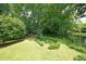 This backyard features a lush green lawn, mature shade trees and landscaped garden areas at 2394 Burch Ne Cir, Brookhaven, GA 30319