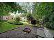 A beautiful backyard with a fire pit, wooden bench, and lush green landscaping, perfect for outdoor entertaining at 2394 Burch Ne Cir, Brookhaven, GA 30319
