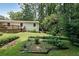 This backyard features a large green lawn, mature trees for privacy and a landscaped garden area at 2394 Burch Ne Cir, Brookhaven, GA 30319
