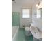 Vintage bathroom featuring a green tile bathtub, matching hexagon floors, and a pedestal sink under a window at 2394 Burch Ne Cir, Brookhaven, GA 30319