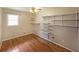 Cozy bedroom features hardwood floors, a ceiling fan, a window, and multiple built-in shelving units for ample storage at 2394 Burch Ne Cir, Brookhaven, GA 30319