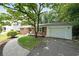 Brick home showcasing a well-maintained lawn, mature trees, and a convenient driveway at 2394 Burch Ne Cir, Brookhaven, GA 30319