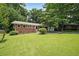 Charming brick home featuring a lush green lawn, mature trees, and a welcoming entrance at 2394 Burch Ne Cir, Brookhaven, GA 30319