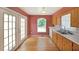 Bright kitchen features hardwood floors, wooden cabinetry, double sinks, and a door leading to the backyard at 2394 Burch Ne Cir, Brookhaven, GA 30319