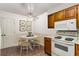 Cozy kitchen nook with oak cabinets, white appliances, and a charming breakfast table, great for casual dining at 408 Coleraine Se, Smyrna, GA 30080