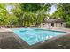 A community pool with clean blue water, lounge chairs, and a covered building surrounded by trees at 408 Coleraine Se, Smyrna, GA 30080