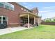 Spacious backyard with a covered patio, seating area, and lush green lawn at 3352 Stone Point Way, Buford, GA 30519