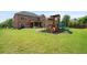 Expansive backyard featuring a play set, grassy lawn and covered patio at 3352 Stone Point Way, Buford, GA 30519