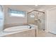Clean bathroom offers a soaking tub, shower with glass, and a view to a window at 3352 Stone Point Way, Buford, GA 30519