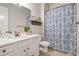 Well-lit bathroom with white vanity, marble countertop, patterned shower curtain, and decorative accents at 3352 Stone Point Way, Buford, GA 30519