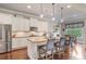 Spacious kitchen featuring white cabinets, stainless steel appliances, granite countertops, and dark hardwood floors at 3352 Stone Point Way, Buford, GA 30519