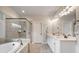 Luxurious main bathroom offers a soaking tub, walk-in shower, neutral tile, and a double vanity at 3352 Stone Point Way, Buford, GA 30519