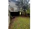 The backyard shows a damaged deck needing replacement, with a view of the overgrown lawn at 5568 Bradley Cir, Lithonia, GA 30038