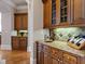 Elegant bar area with custom cabinetry, granite countertops, and stylish tile backsplash at 8295 St Marlo Fairway Dr, Duluth, GA 30097