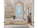 Luxurious bathroom featuring a large soaking tub, stained glass window, and a separate glass shower at 8295 St Marlo Fairway Dr, Duluth, GA 30097