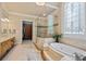 Bright bathroom featuring a large soaking tub, glass shower, double vanity, and walk-in closet at 8295 St Marlo Fairway Dr, Duluth, GA 30097