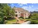 Stunning brick home featuring an elegant entrance with a balcony, landscaped yard, and meticulously maintained lawn at 8295 St Marlo Fairway Dr, Duluth, GA 30097