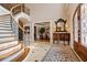 Grand foyer featuring a curved staircase, tile flooring with black accents, and a view into the dining room at 8295 St Marlo Fairway Dr, Duluth, GA 30097