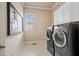 Modern laundry room with side-by-side washer and dryer and plenty of storage space at 8295 St Marlo Fairway Dr, Duluth, GA 30097