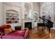 Elegant living room featuring a fireplace, built-in shelves, piano, hardwood floors, and large windows at 8295 St Marlo Fairway Dr, Duluth, GA 30097