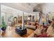 Open-concept living room with hardwood floors, elegant furnishings, and a view of the kitchen and dining area at 8295 St Marlo Fairway Dr, Duluth, GA 30097