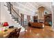 Spacious living room with hardwood floors, a fireplace, built-in shelves, and a staircase to the second floor at 8295 St Marlo Fairway Dr, Duluth, GA 30097