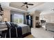 Spacious main bedroom with a ceiling fan, a large bed, and a connected office space at 8295 St Marlo Fairway Dr, Duluth, GA 30097