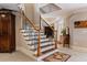 Elegant staircase with wooden handrails, decorative iron spindles, and a view of the entryway at 8295 St Marlo Fairway Dr, Duluth, GA 30097