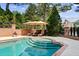 Enjoy this beautiful pool with a tanning ledge, surrounded by lush landscaping and an umbrella for shade at 8295 St Marlo Fairway Dr, Duluth, GA 30097