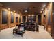 Home theater featuring plush seating, wood-paneled walls, and integrated lighting for an immersive experience at 8295 St Marlo Fairway Dr, Duluth, GA 30097