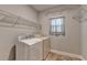 Bright laundry room features a washer, dryer, tile flooring and plenty of storage shelving above at 3112 Patriot Sw Sq, Marietta, GA 30064