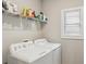 Bright laundry room with white washer, dryer, and storage shelves at 3112 Patriot Sw Sq, Marietta, GA 30064
