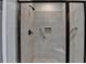 Modern tiled shower featuring glass doors, a seat, and handrails at 3112 Patriot Sw Sq, Marietta, GA 30064