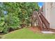 Multi-level backyard deck surrounded by lush trees, stairs leading to the lawn at 554 Grand Ashbury Ln, Sugar Hill, GA 30518